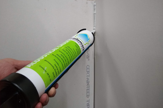 Applying acoustical caulk to drywall